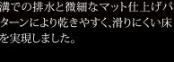 溝での排水と微細なマット仕上げパターンにより乾きやすく、滑りにくい床を実現しました。